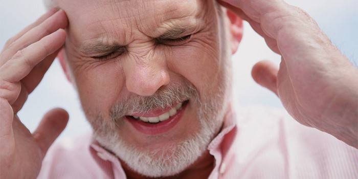 Мужчина держится за виски руками